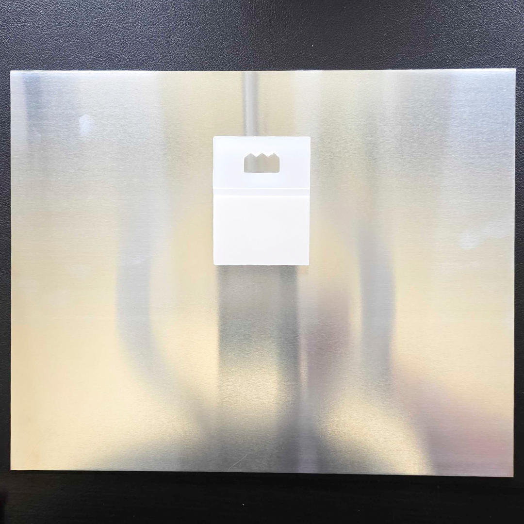 8x10 swappable photo frame back showing the peel-and-stick hanger clip on brushed aluminum for set-once mounting